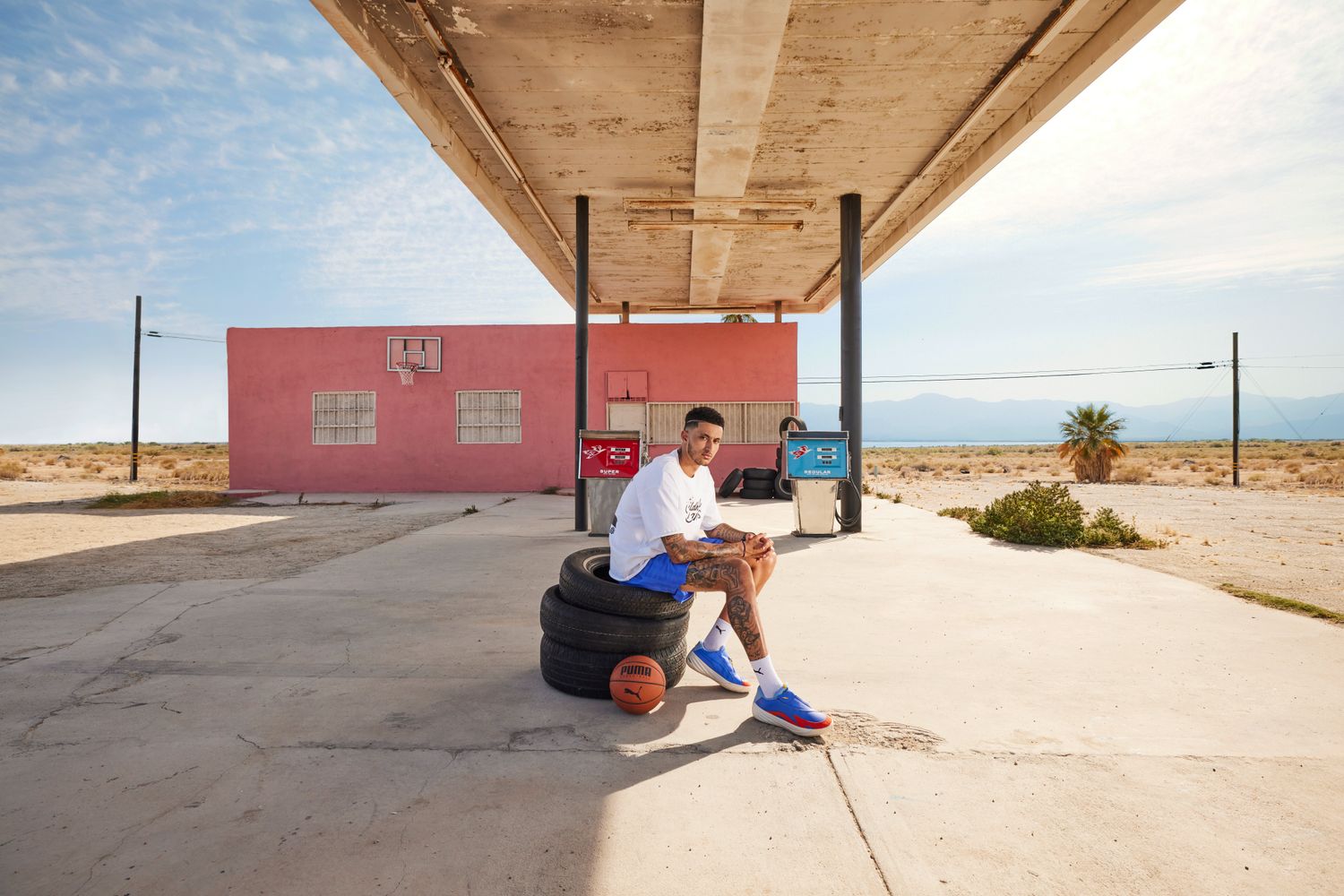 Kyle Kuzma models PUMA apparel at a gas station.
